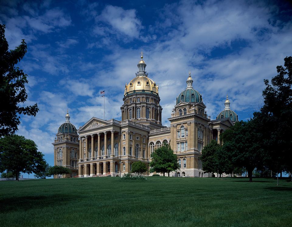 Iowa State Capitol in Des Moines surrounded by trees and lawn
